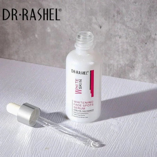 Dr. Rashel Whitening Fade Spots Serum bottle with dropper on white surface, concrete background