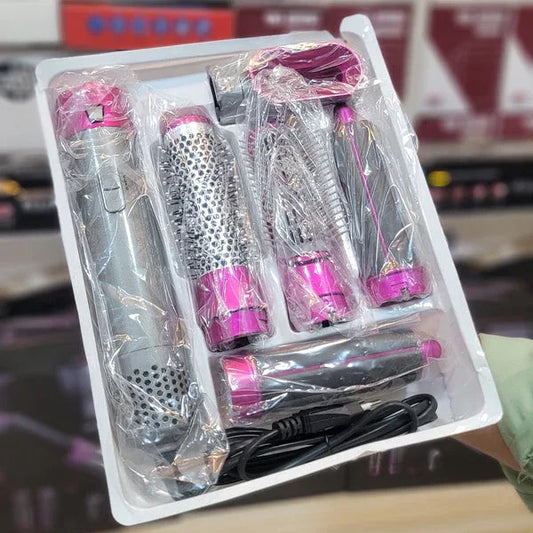 Set of hair styling tools in a clear plastic packaging on a wooden surface.