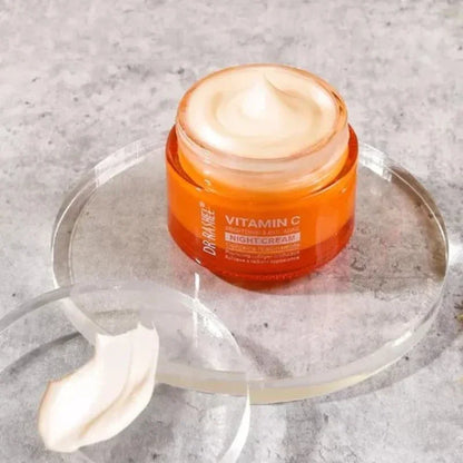 Open jar of Dr. Rashel Vitamin C night cream on clear round tray with cream texture on lid